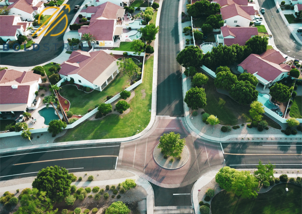 "Aerial view of a serene small town, showcasing a tree-lined street intersecting at a junction, surrounded by houses and buildings in a suburban residential setting.